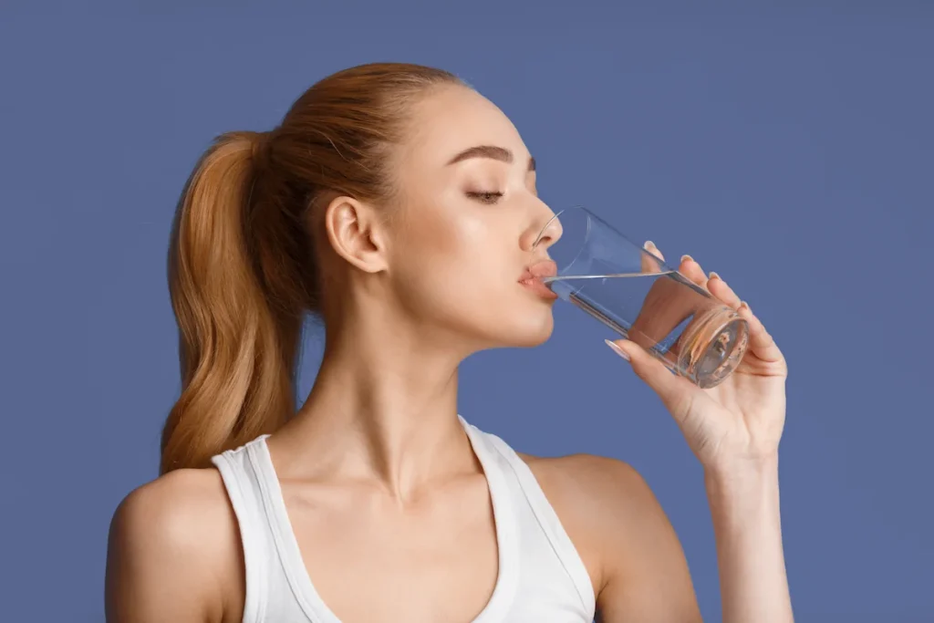 Une femme qui boit de l'eau pour perdre du poids