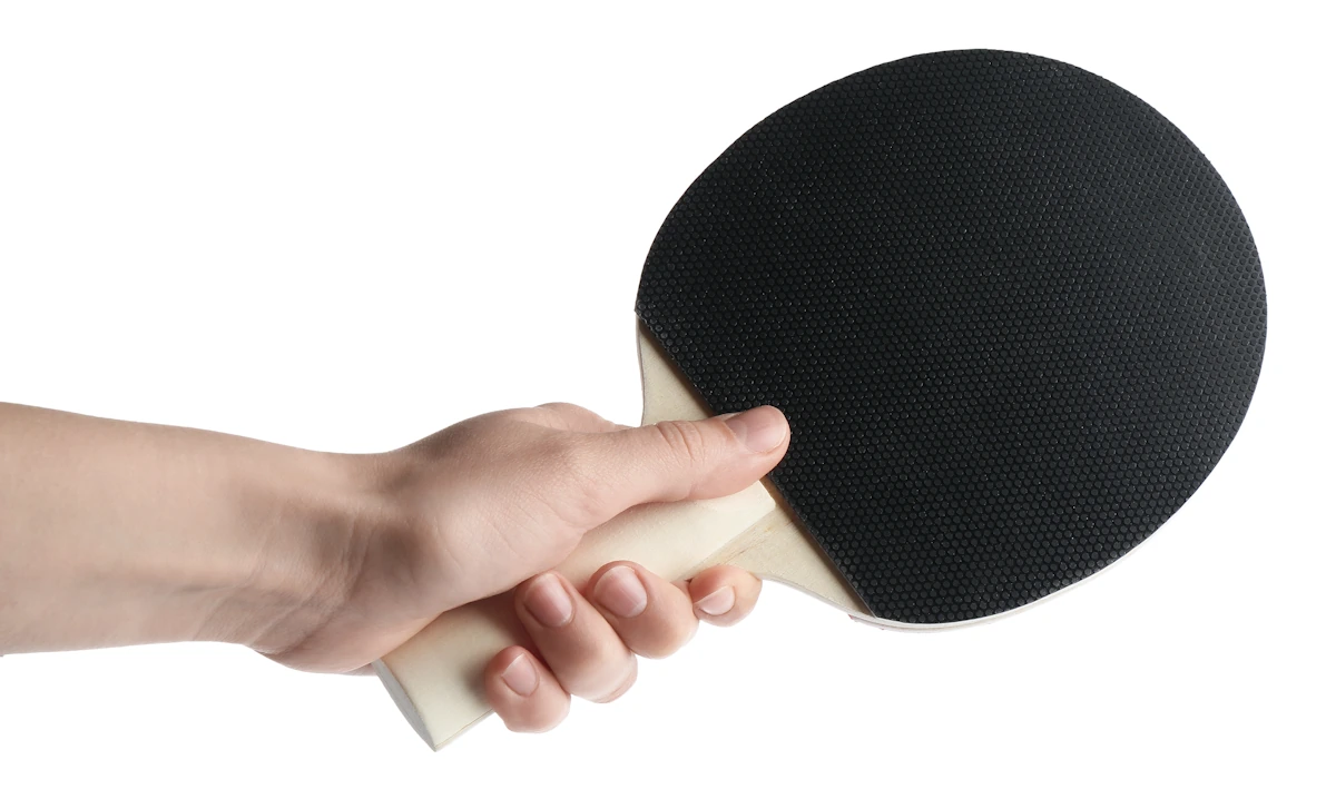 Une personne qui tient une raquette ping pong