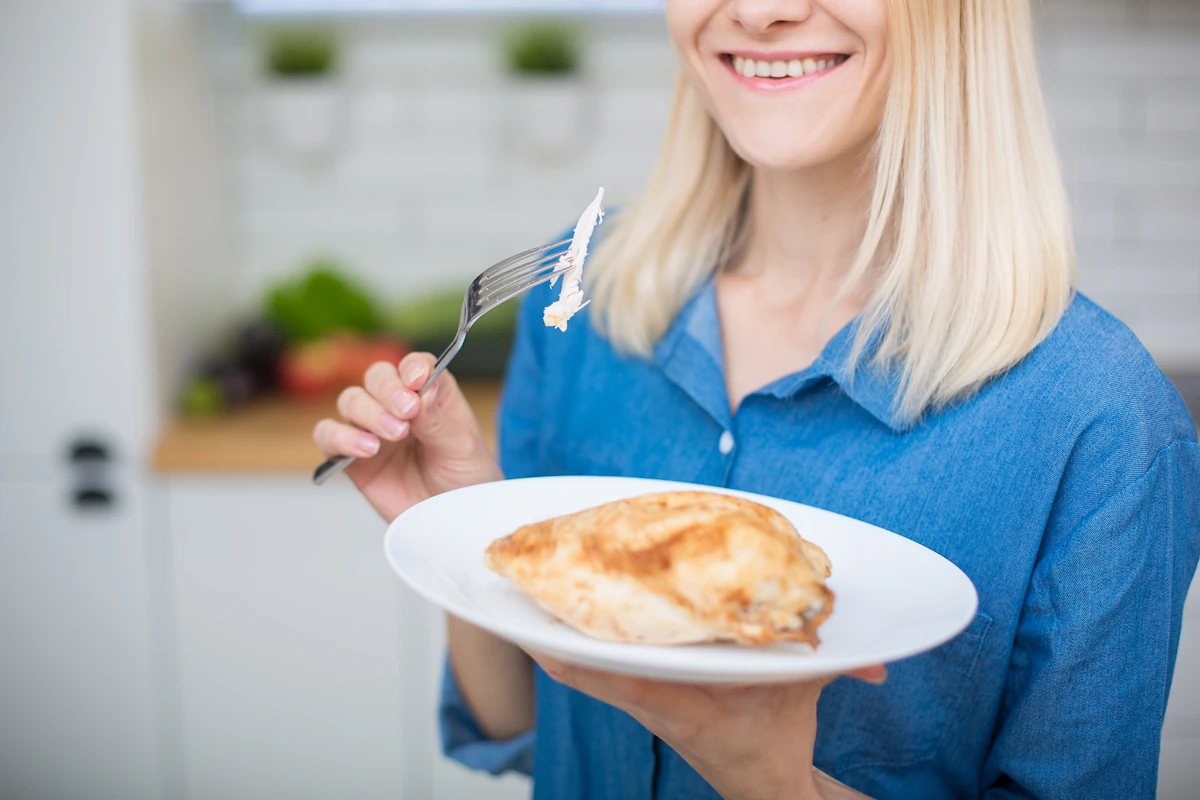 Une femme qui mange de la volaille